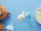 Bear, bottle and baby formula on blue background